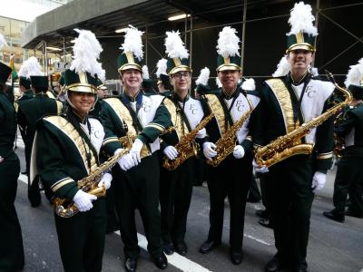 Students in marching band holding saxaphones.